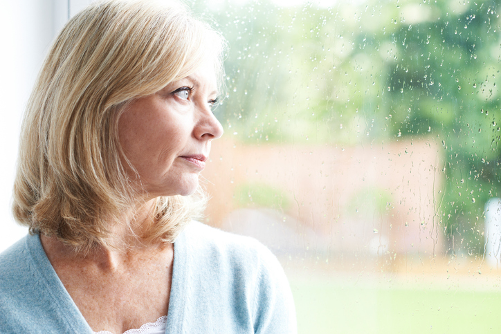 Wistful older women looking out of window